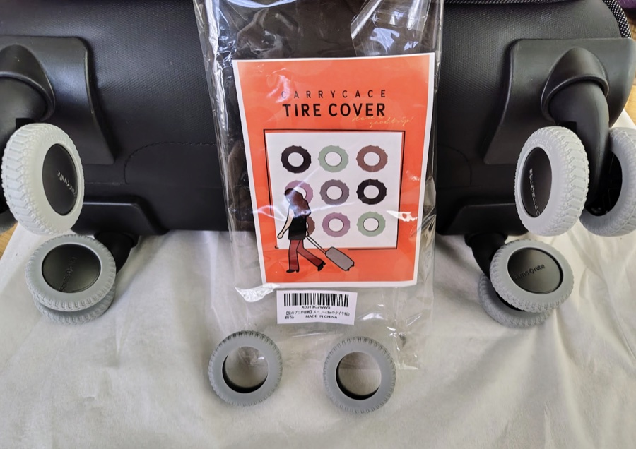 キャリーバッグの車輪にタイヤカバーを取りつけたところ。予備のカバーと商品の袋も並べている