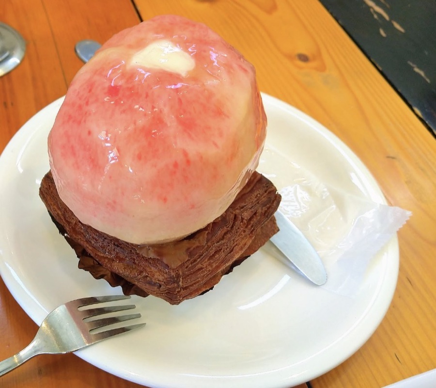 パイ生地の上にまるごとの桃がのった桃のタルト