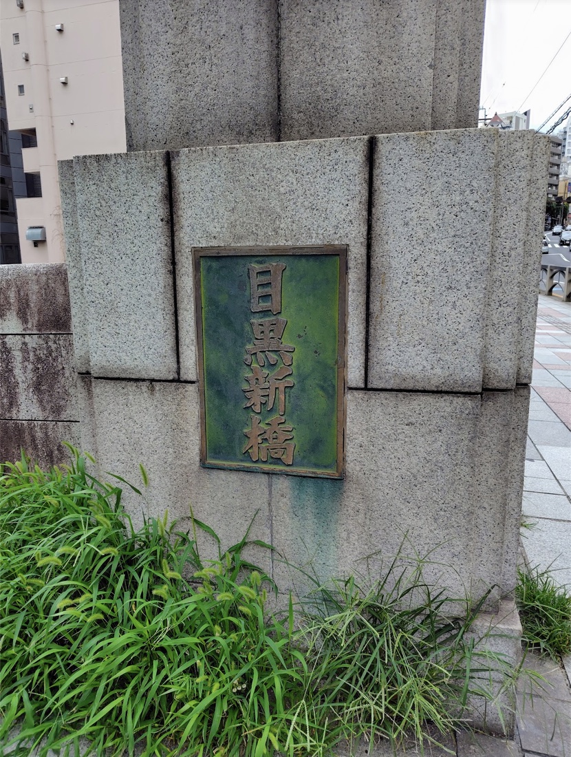 目黒新橋の橋名標。坂道の途中にある古い石造りの橋