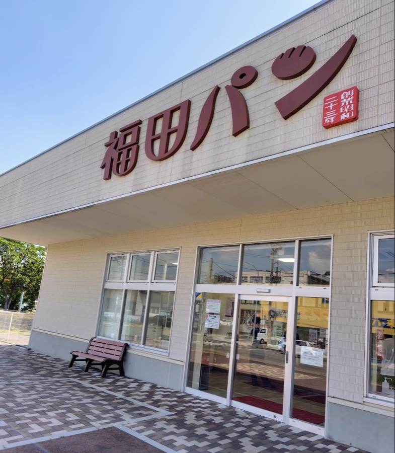 福田パンの外観。青空に「福田パン」の大きな文字と「創業昭和二十三年」の看板