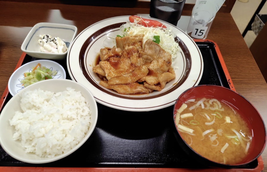 生姜焼き定食。ごはん、味噌汁、小鉢がふたつ